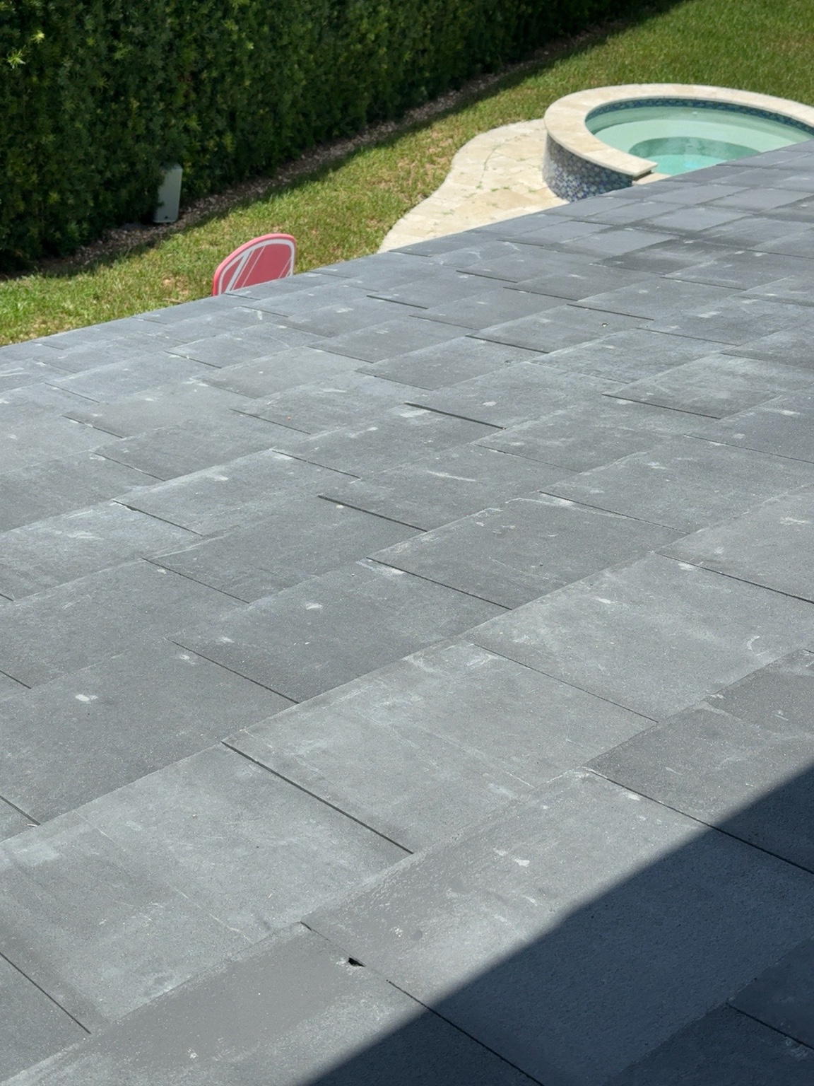 Dark gray concrete roof tiles showing lighter gray surface variation
